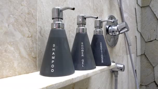 Shower in a bathroom and shampoo soap and the conditioner on the shelf — ストック動画