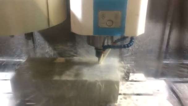 La fresadora con el CNC procesa un molino un detalle de acero. En el tratamiento del detalle se usa el líquido de enfriamiento — Vídeo de stock