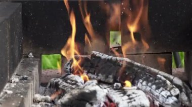 Caddedeki bir brazier 'da yanan ahşap kütükler, kır evindeki sokak mangasında yanan ahşap raflar, açık ateşte barbekü hazırlığı için kömür hazırlığı, barbekü., 