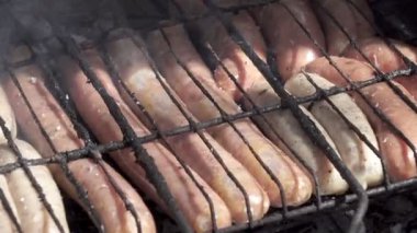 Mangalda ızgara sosisler kızartılmış ve mangal mangalında tütsülenmiş. Doğal kabuklu sosisler. Ateşin üstünde ızgara yapan lezzetli sosisler., 