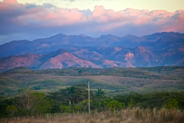 灿烂的落日笼罩在布满热带植物的山丘上 — 图库照片