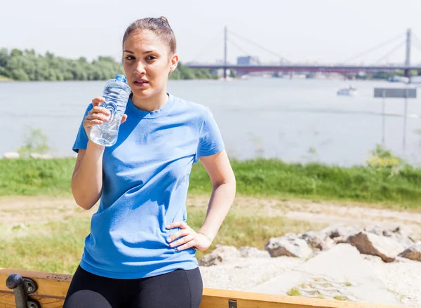 健身女孩休息 运动妇女在户外运动后举行瓶装水 — 图库照片