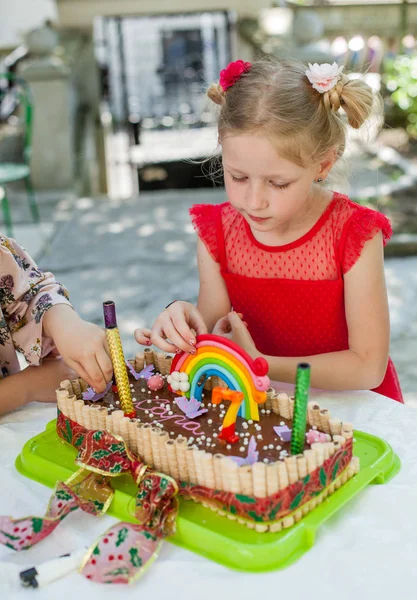 おいしいケーキと赤いドレスの少女の肖像画を幸せな誕生日を祝う屋外 — ストック写真