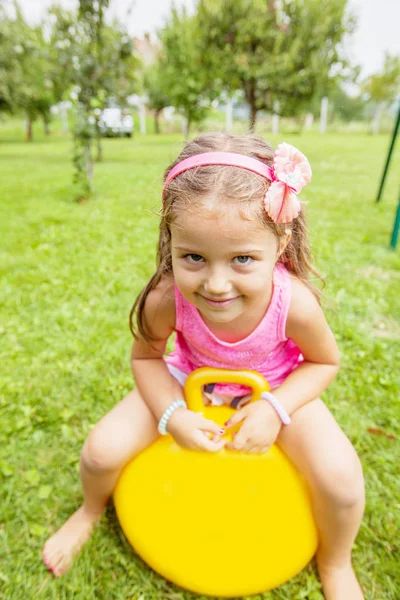 夏の日に自然の中の緑の野原でボール遊び心のある幸せの小さな女の子 — ストック写真