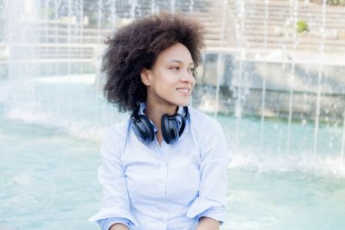 Kulaklıklar açık ile güzel gülümseyen karışık yarış genç kadının portresi