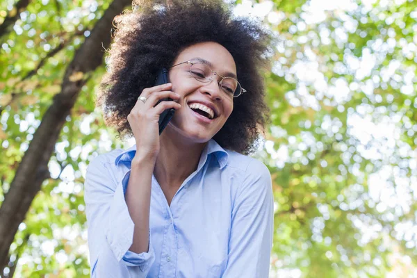 Çok güzel genç kadın telefonla konuşan gözlüklü siyah. Açık portre, giyim, aşağı arıyorsunuz