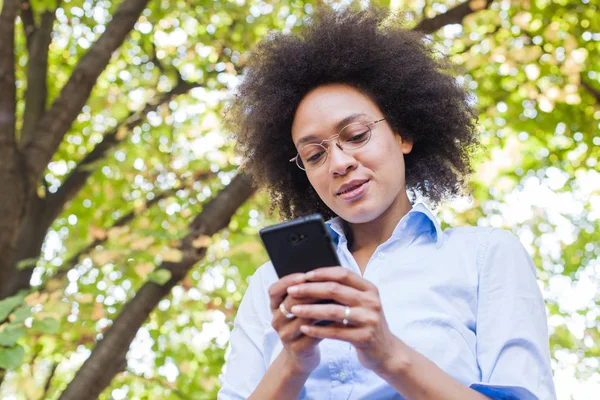 Krásná Mladá Afričanka Pomocí Telefonu Přírodě Venkovní Portrét Nosí Brýle — Stock fotografie