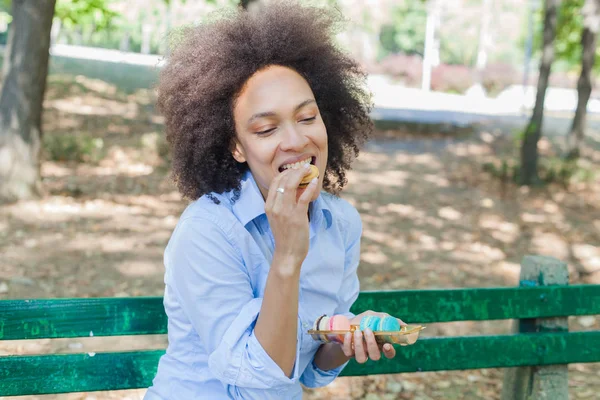 Joyeuse Jeune Femme Africaine Mangeant Des Macarons Cookie Dans Parc — Photo