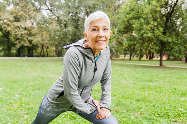 Mature Fit Woman In Sportswear Doing Fitness Exercise In Nature, Workout Outdoor.