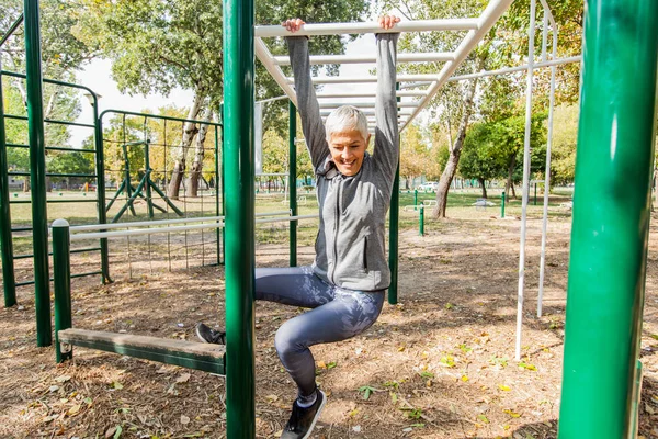 Açık spor salonunda, sağlıklı yaşam tarzı germe kadın kıdemli uygun.