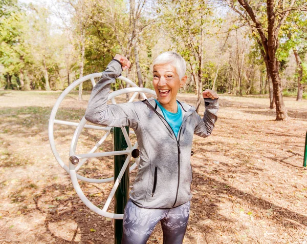 Happy Fit Successful Senior Woman Raised Arms At Outdoor Gym. Shows Strength And Winning. Activity Old People Fitness Lifestyle