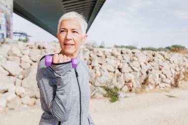 Sağlıklı Olgun kadın egzersiz egzersiz açık ile ağırlıkları, gri-kısa saç, spor giyim, .