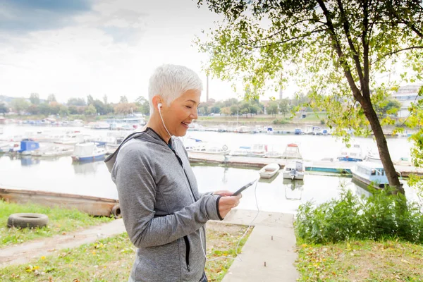 Porträt Einer Seniorin Die Musik Hört Nachdem Sie Flussufer Gelaufen — Stockfoto