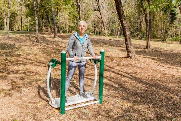 Elderly Woman In Sports Clothes Exercising At Outdoor Fitness Park, Healthy Lifestyle Mature People.