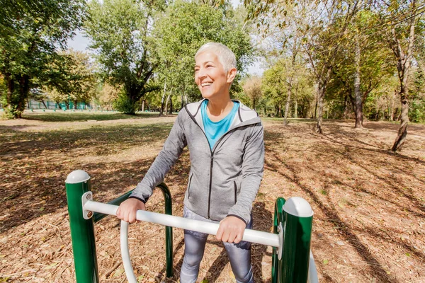 Elderly Woman In Sports Clothes Exercising At Outdoor Fitness Park, Healthy Lifestyle Mature People.