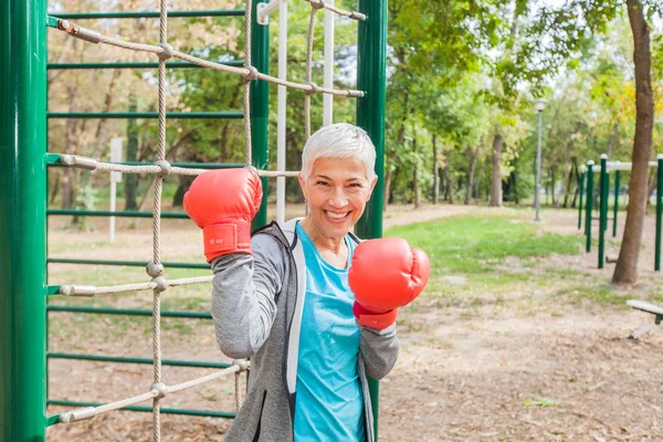 Portrait Of Fit Senior Woman With Boxing Glove At Outdoor Fitness Park In Sportswear. Active Old People Healthy Lifestyle