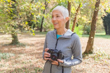 Retro kamera alarak fotoğraf ormandaki için hazır ile kadın Olgun.