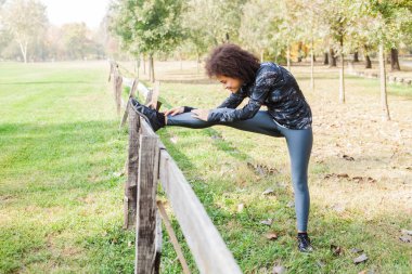 Afrikalı kadın Parkı'nda sabah çalıştırdıktan sonra ahşap çit germe. Kopya alanı motivasyon teklif için.