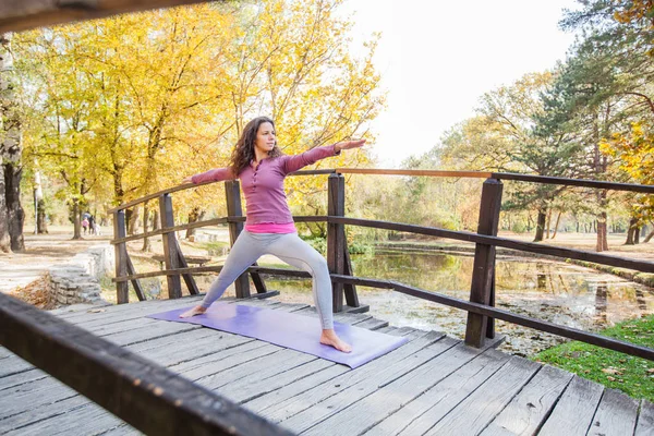 Jonge Vrouw Uitvoeren Van Yoga Oefening Warrior Pose Houten Brug — Stockfoto