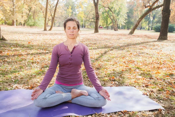 ロータス ポーズ Padmasana の練習の女性 公園で日当たりの良い秋の日に瞑想 屋外トレーニング — ストック写真