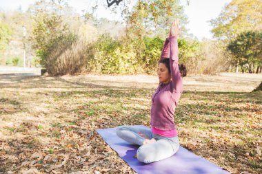 Meditasyon ve Yoga, Lotus poz, Padmasana pratik bir kadın. Meditasyon sonbahar güneşli Park. Egzersiz açık.
