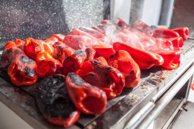 Ahşap ocakta kırmızı biberleri ızgarada pişirmek - Sırbistan 'da geleneksel lezzetli yemekler hazırlamak.