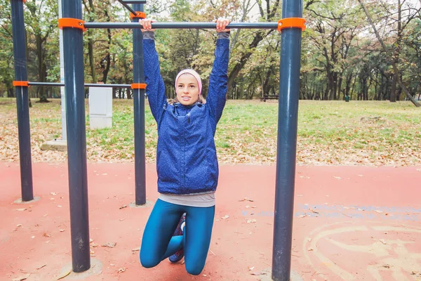 健身的年轻女子在户外健身房做拉上运动 早上在秋季公园运动的女孩运动 — 图库照片
