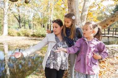 Mutlu aile lake Park yakınındaki güzel sonbahar günü, eğlenelim. Kızları annesiyle zevk doğa.