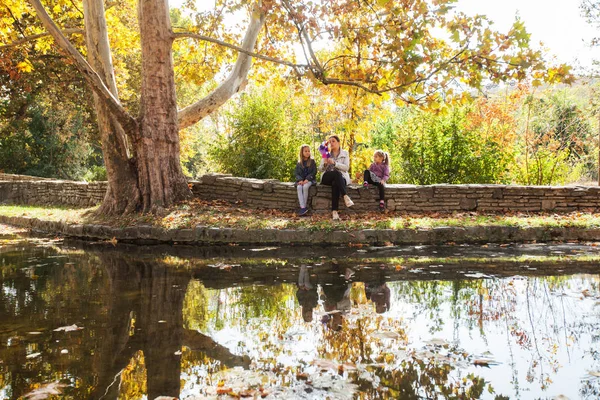 Mutlu aile rahatlatıcı güzel sonbahar günü gölde Park yakınındaki. Su yansıma.