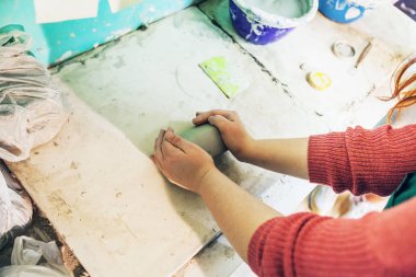 Bayan potter kil çömlek atölyesi'nde masada kalıplama eller. Üstten görünüm.