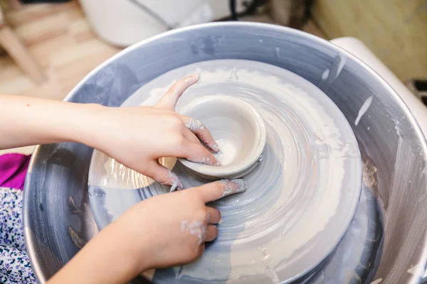 Creative children hands - Making arts - Shaping clay on pottery wheel - Creativity workshop.