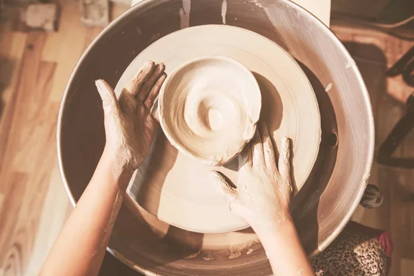 车间里年轻陶工手在陶瓷轮上形成陶瓷瓶 — 图库照片