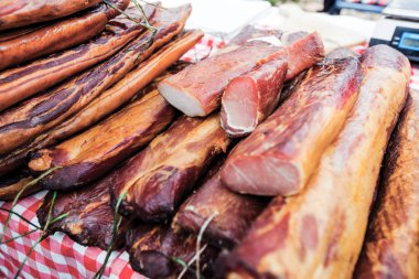 Tütsülenmiş etin seçilmiş yardımcısı, yerel çiftçi pazarında Sırp el yapımı geleneksel yiyecekler.