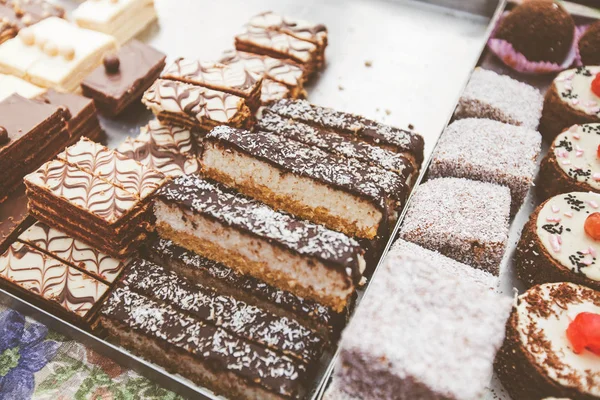 Different types of fresh handmade cakes for sale at sweet food market.