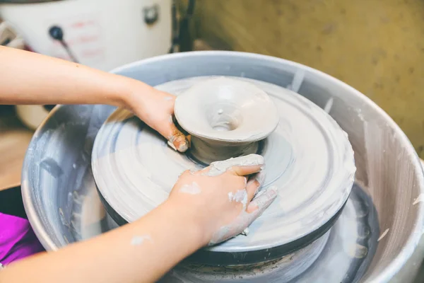 Jonge potter handen werken met klei op aardewerk wiel — Stockfoto