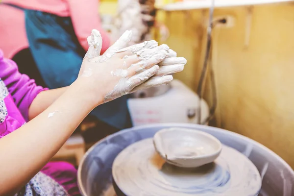 Jonge potter handen werken met klei op aardewerk wiel — Stockfoto