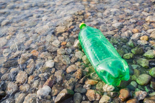 Plastic flessen afval op rivieroever, watervervuiling concept — Stockfoto