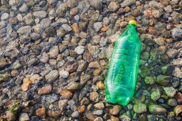 Plast Flask avfall på Rivershore, vattenförorening Concept — Stockfoto