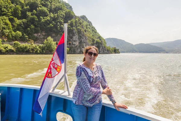 Woman on river cruise with Serbian national flag enjoy view of Danube gorge — Stock Photo, Image