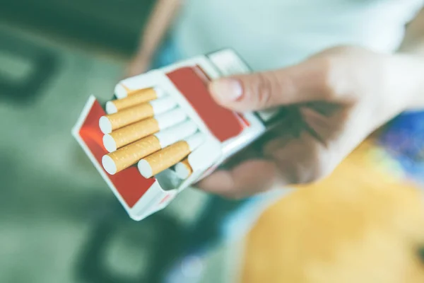 Las manos femeninas sostienen el paquete de cigarrillos, se preparan para fumar cigarrillos —  Fotos de Stock