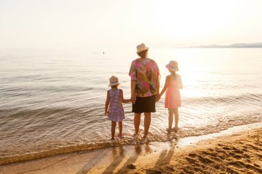 Yaz tatilinde gün batımında kum plajında aile dikiz dinlenmek