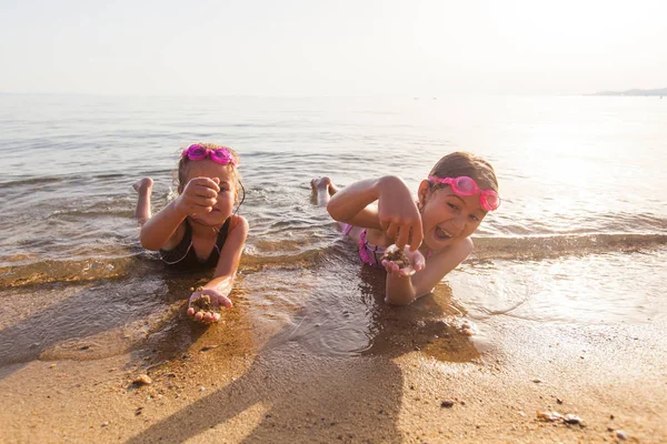 Щасливі маленькі дівчата грають на піщаному пляжі на літніх канікулах — стокове фото