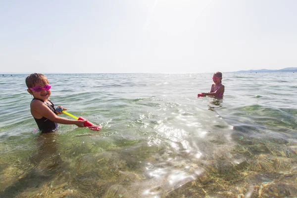 Щасливі діти розважаються у морській воді на літніх канікулах — стокове фото