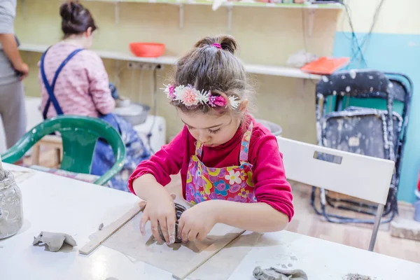 Маленькая девочка в мастерской по изготовлению глиняной вазы — стоковое фото
