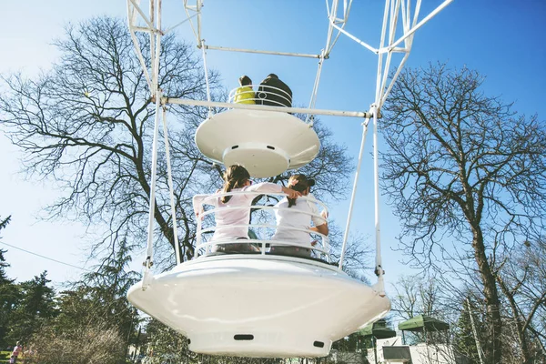 Дети веселятся на аттракционе парк-драйв с ретро колесо обозрения над голубым небом — стоковое фото