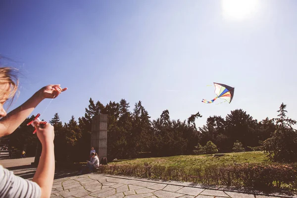 Kleines Mädchen hält am Frühlingstag bunten Drachen im Park — Stockfoto