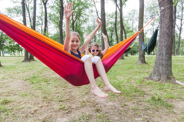 Adoráveis meninas relaxando na rede na floresta — Fotografia de Stock