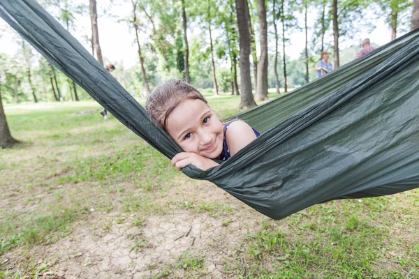 Retrato feliz de menina relaxar na rede na floresta — Fotografia de Stock