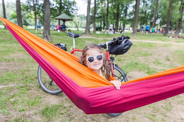 Gelukkig portret van klein meisje ontspannen op hangmat in bos — Stockfoto