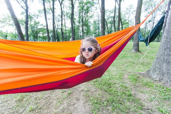 Gelukkig portret van klein meisje ontspannen op hangmat in bos — Stockfoto